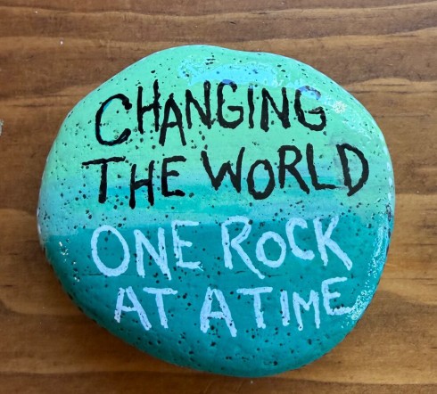 Painted kindness rock with text "Changing the world one rock at a time"